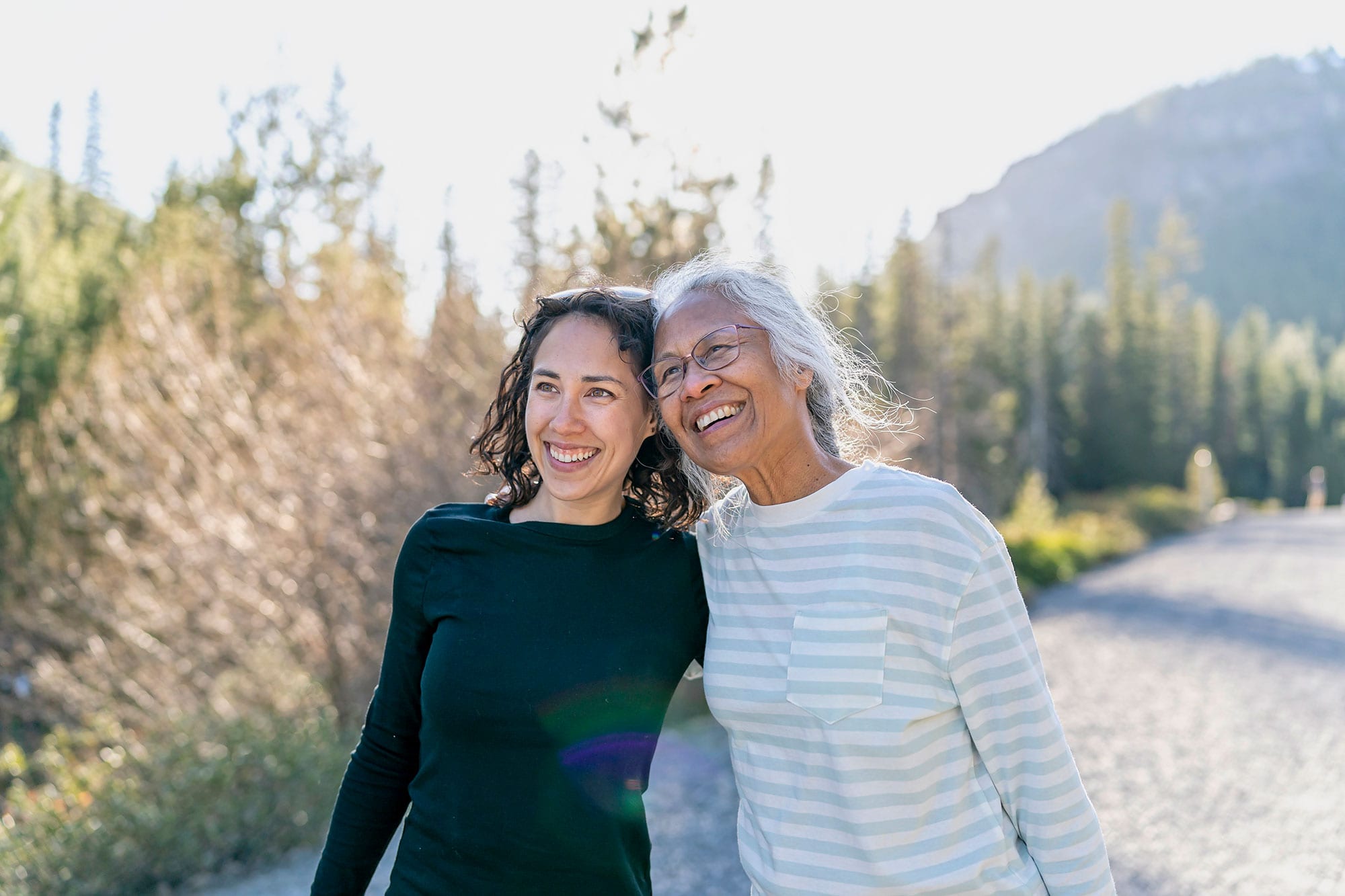 Happy senior woman and her adult daughter walking outdoors.jpg