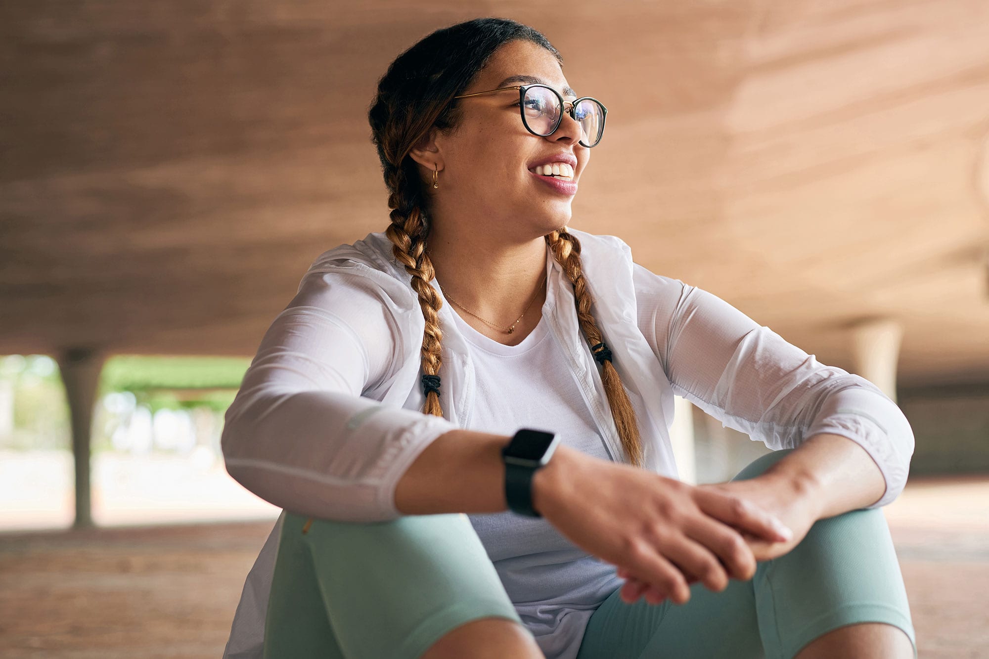 Shot of a sporty young woman taking a break while exercising outdoors