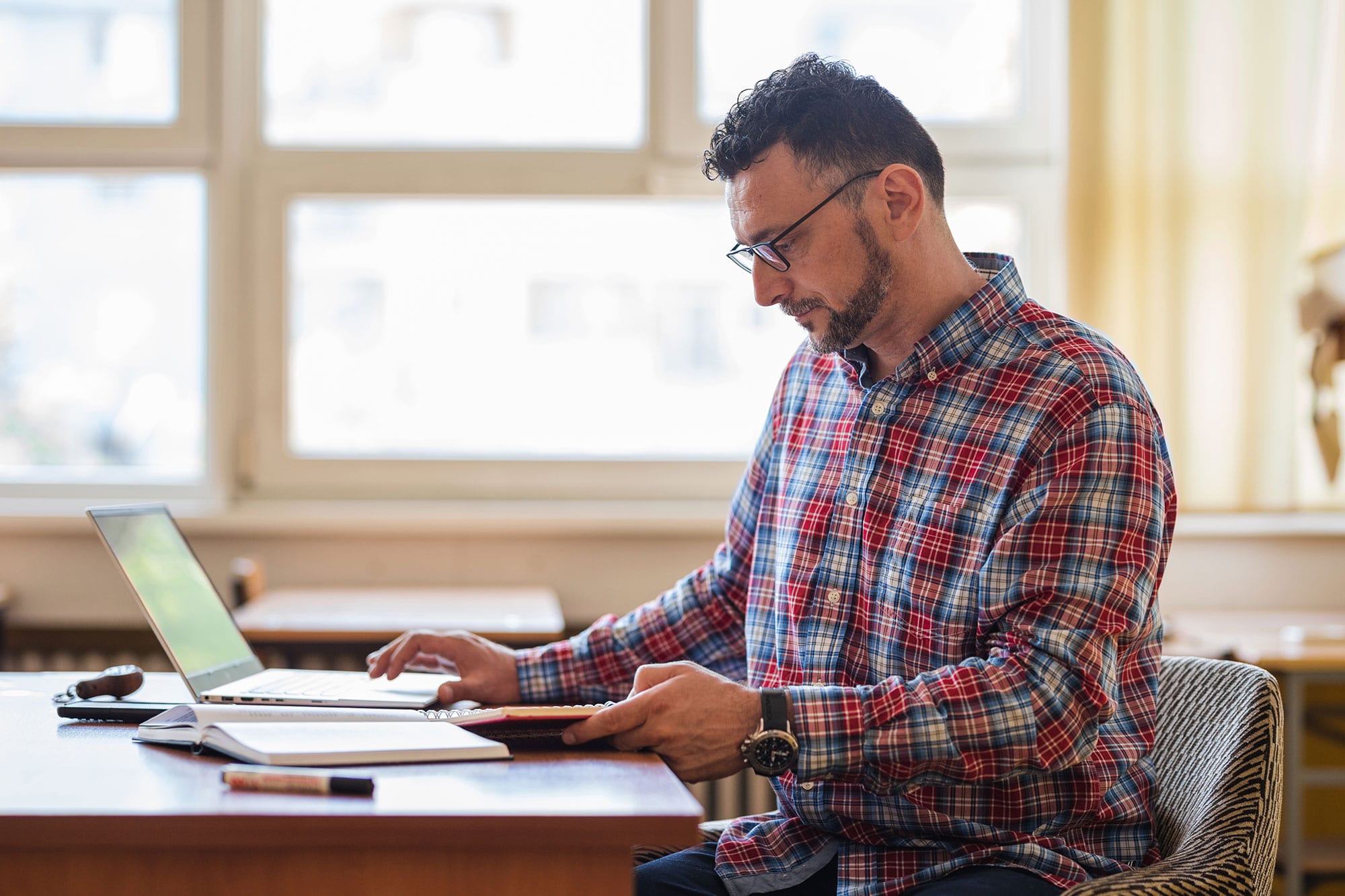 Teacher taking notes on laptop